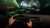 Drivers hands are on the wheel, driving through a hyper real tunnel with green trail lights infront