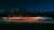 Light trail of a car driving fast on a road at night with the city in the background