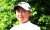 A smiling female Golfer wearing a white cap.